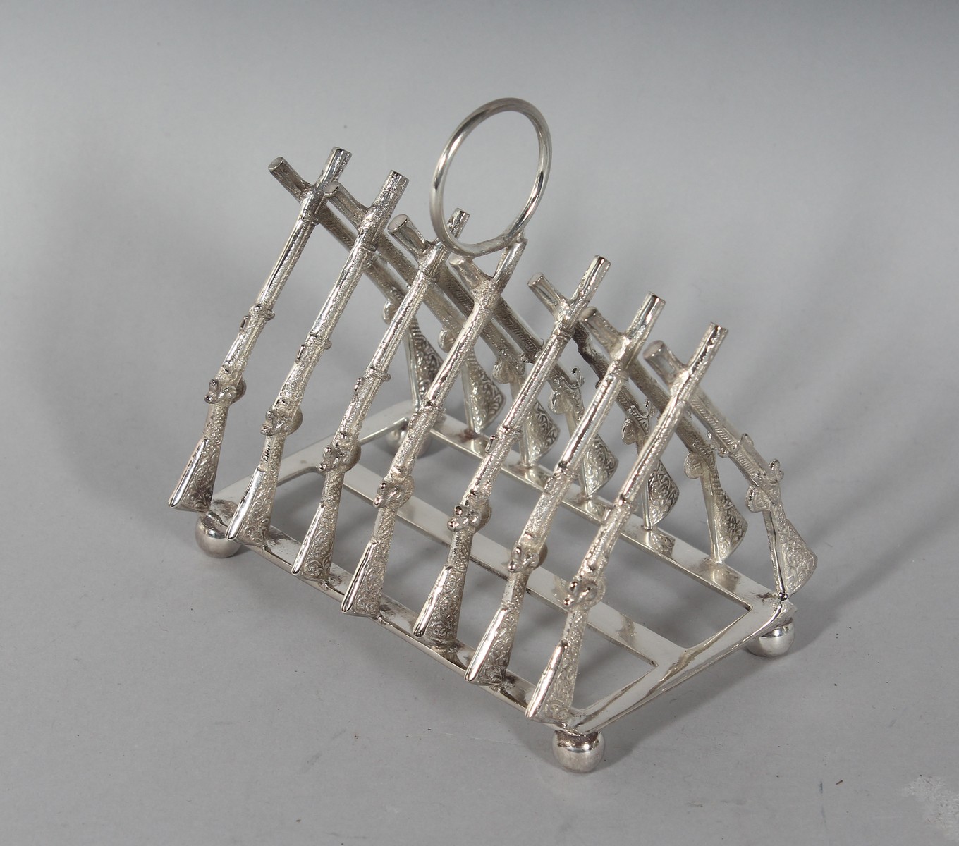 A SIX-DIVISION CROSSED RIFLES TOAST RACK. 4ins long.