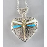 A SILVER FILIGREE DRAGONFLY ENAMEL HEART SHAPED LOCKET on a chain.