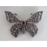 A 9CT GOLD, SILVER SET, AMETHYST AND DIAMOND BUTTERFLY BROOCH.