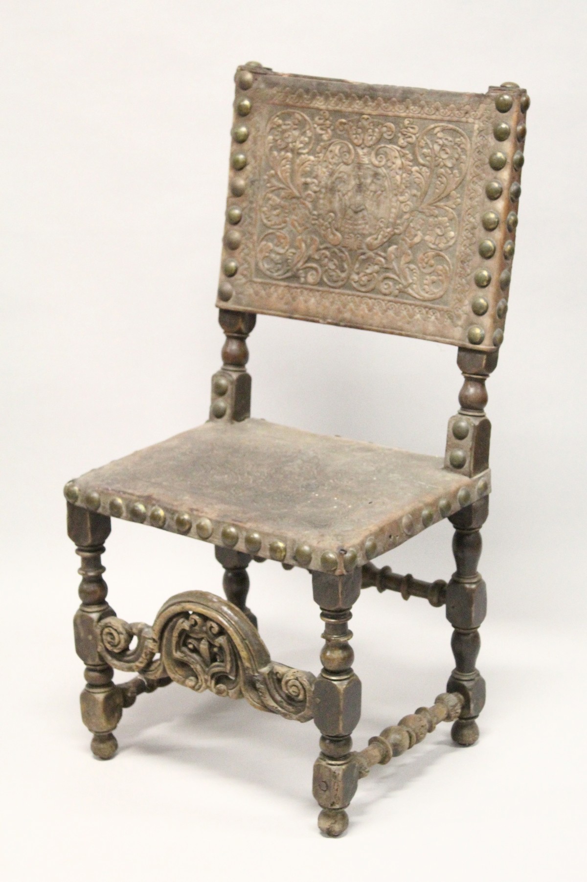 A 17TH CENTURY OAK SIDE CHAIR, with heavy brass studded embossed leather back and seat, turned