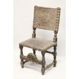 A 17TH CENTURY OAK SIDE CHAIR, with heavy brass studded embossed leather back and seat, turned