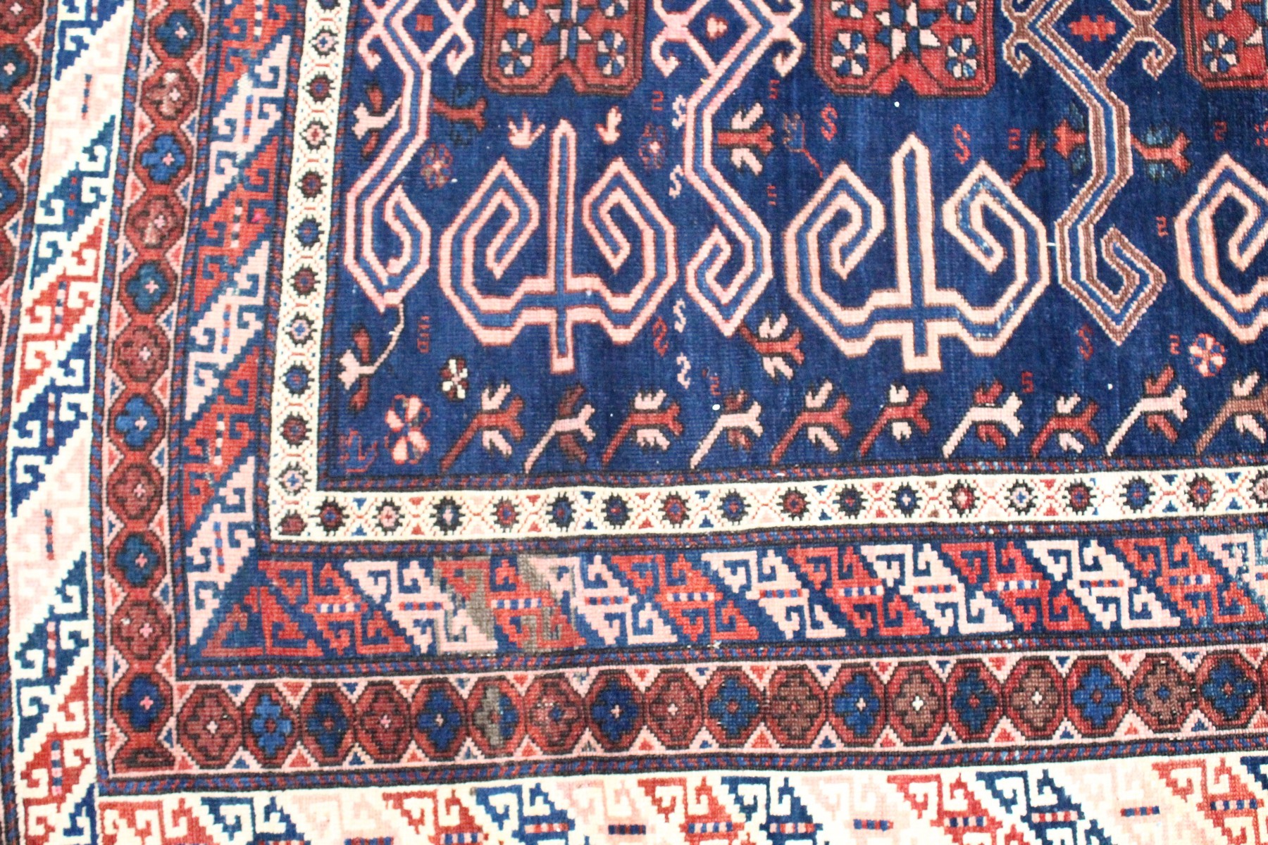 A CAUCASIAN RUG, mid 20th century, dark blue ground with stylised decoration within a five row - Image 2 of 5
