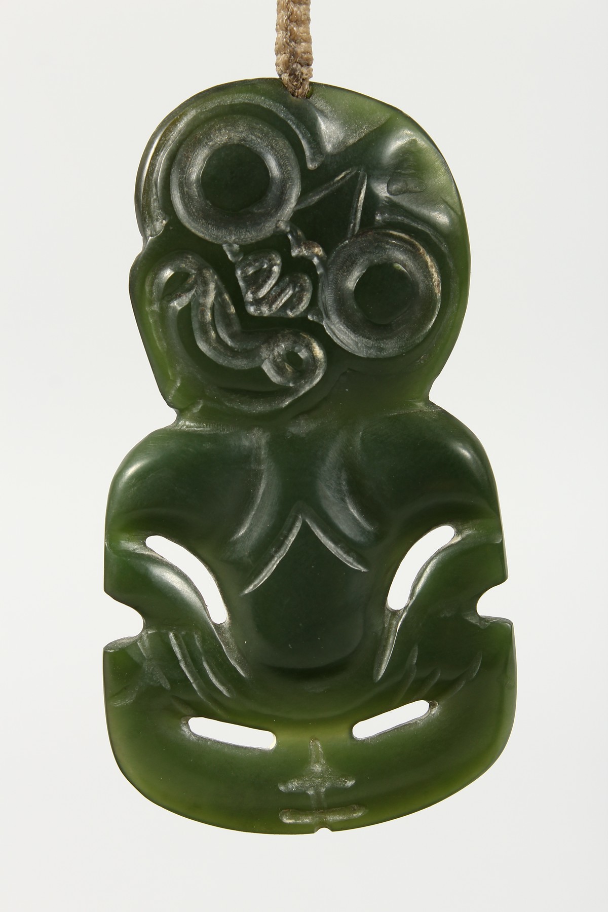 A NEW ZEALAND CARVED JADE TIKKI, suspended from a hardwood frame. Tikki: 2.75ins high. - Image 3 of 5