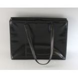 A LARGE BLACK PATENT BAG.