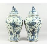 A PAIR OF 20TH CENTURY CHINESE BLUE AND WHITE BALUSTER SHAPE TEMPLE JARS AND COVERS, painted with