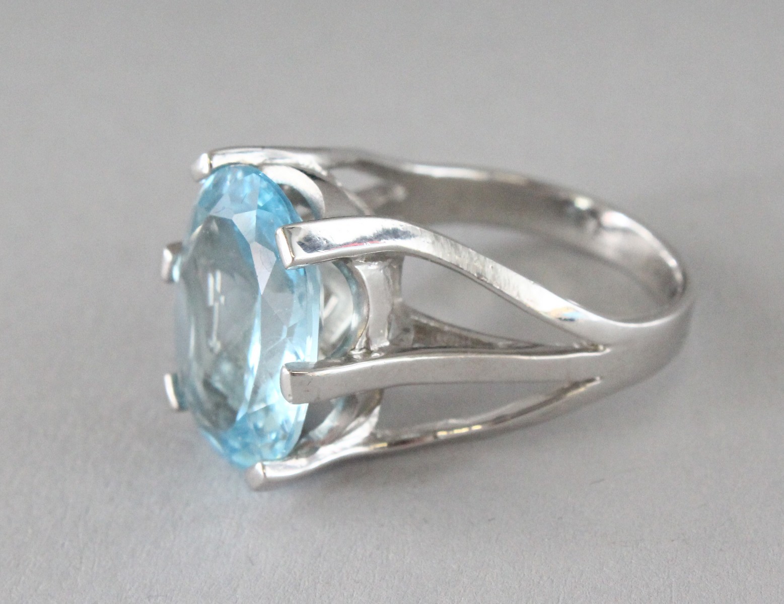 A SILVER LARGE OVAL CUT TOPAZ RING.