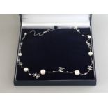 A CHANEL PATTERN SILVER, PEARL AND CZ LONG NECKLACE.
