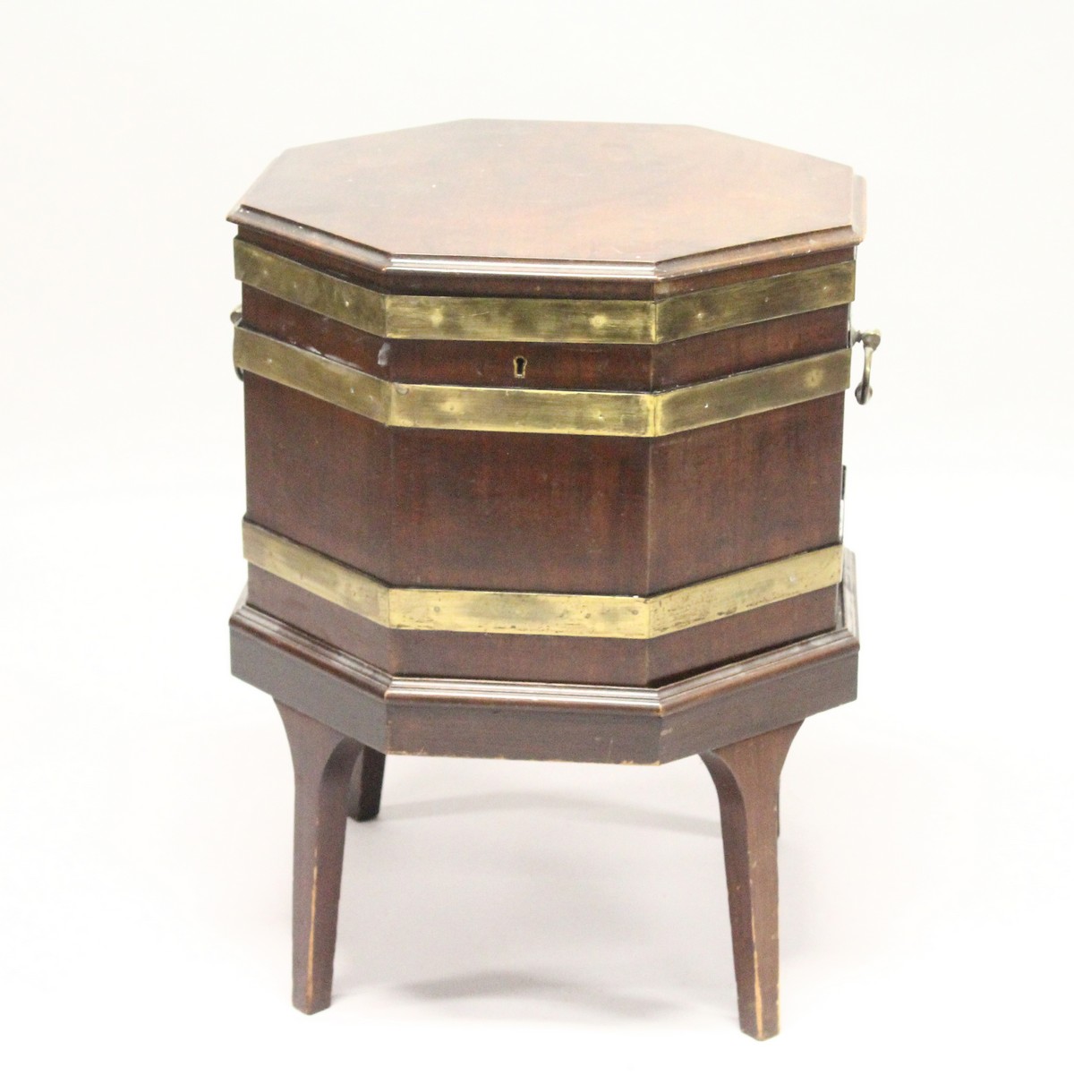 A GEORGE III MAHOGANY AND BRASS BOUND OCTAGONAL CELLARETTE , on tapering square legs. 1ft 8ins