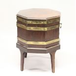 A GEORGE III MAHOGANY AND BRASS BOUND OCTAGONAL CELLARETTE , on tapering square legs. 1ft 8ins