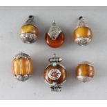 SIX AMBER AND SILVER PENDANTS.
