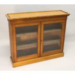 A VICTORIAN LIGHT OAK TWO-DOOR BOOKCASE, with a pair of glazed doors enclosing adjustable shelves,