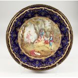A VERY GOOD FRENCH ENAMEL CIRCULAR DISH, painted with a scene, lady on a swing with children. 5ins