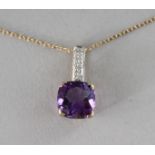 A 9CT GOLD, CUSHION CUT AMETHYST AND DIAMOND PENDANT on a chain.