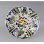 AN EARLY SPANISH FAIENCE DISH in mainly blue and yellow. 10.5ins diameter.