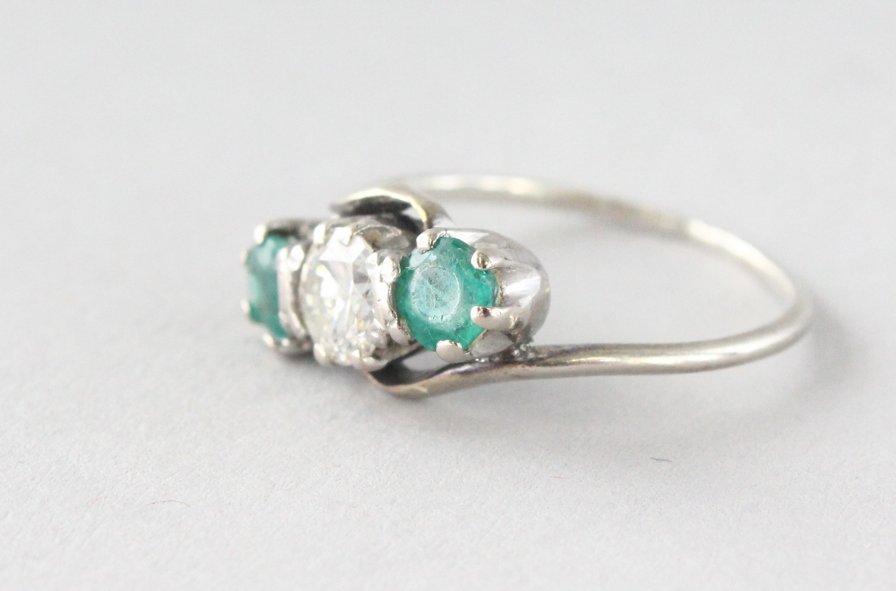 AN 18CT GOLD THREE-STONE DIAMOND AND EMERALD RING. - Image 3 of 4