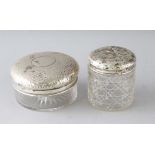 A HAMMERED SILVER CIRCULAR GLASS PIN BOX with silver top, 3.75ins diameter, Birmingham 1910, and a