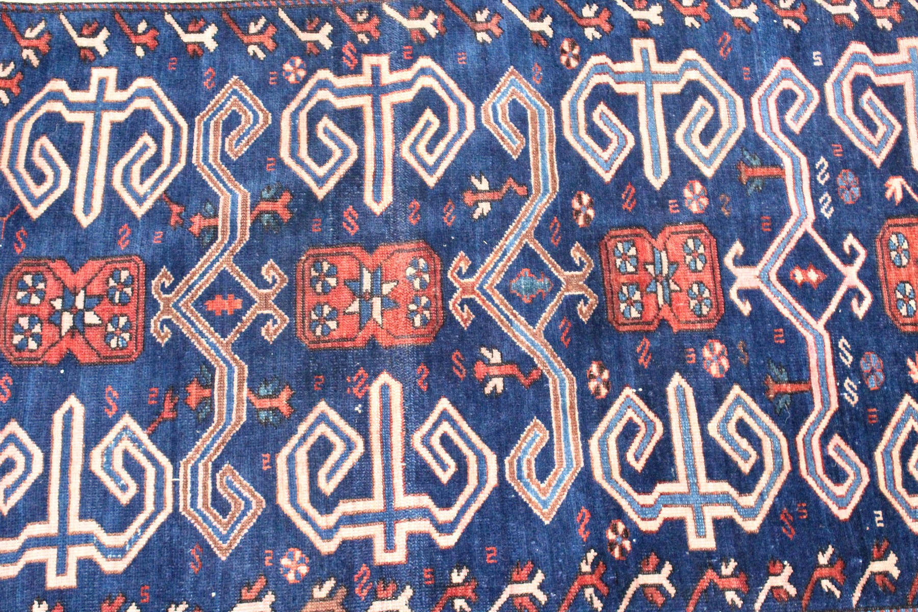 A CAUCASIAN RUG, mid 20th century, dark blue ground with stylised decoration within a five row - Image 3 of 5