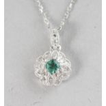 AN 18CT WHITE GOLD, EMERALD (0.11cts) AND DIAMOND (0.09cts) VINTAGE PENDANT on a chain.