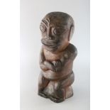 A CARVED WOOD NATIVE FIGURE with arms crossed. 13ins high.