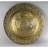 AN 18TH CENTURY BRASS CIRCULAR ALMS DISH repousse with figures carrying grapes. 17.5ins diameter.