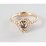 AN 18CT YELLOW GOLD PEAR SHAPED CHAMPAGNE DIAMOND RING, 0.57cts, surrounded by eighteen rose