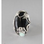 A SILVER, ONYX AND OPAL FROG RING.