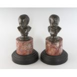 A SMALL PAIR OF GRAND TOUR BRONZE BUSTS on marble bases. 5ins high.