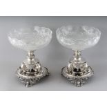 A PAIR OF PLATED CENTREPIECES with circular cut glass bowls on a stand with three elephant mounts,