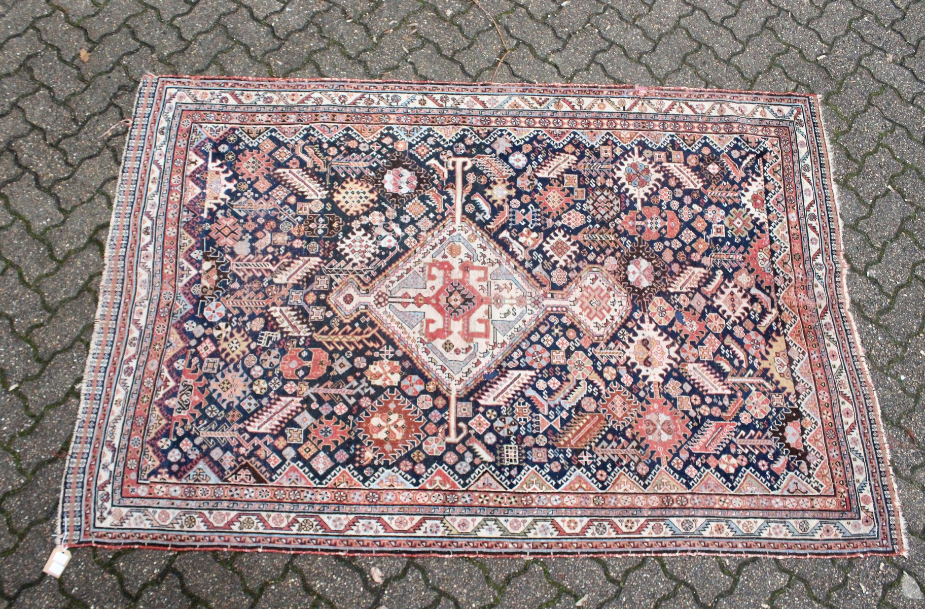 A PERSIAN QASHQAI RUG, early 20th century, dark blue ground with a central diamond shaped panel. 7ft