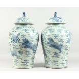 A PAIR OF 20TH CENTURY CHINESE BLUE AND WHITE BALUSTER SHAPE TEMPLE JARS AND COVERS, painted with
