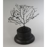 A BLACK CORAL SPECIMEN on a circular wooden base. 4.5ins high.