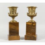 A SUPERB PAIR OF REGENCY BRONZE TWO-HANDLED URNS on marble stands. 9.5ins overall.