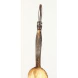 A HORN SPOON, the handled carved with a figure. 12ins long.