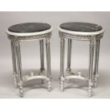 A GOOD PAIR OF SILVERED OVAL TABLES with marble tops. 28ins high.