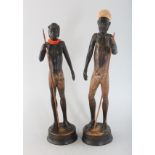 A PAIR OF CARVED WOOD STANDING FIGURES IF A MAN AND WOMAN on circular bases. 9.5ins high.