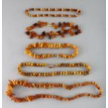 FIVE VARIOUS AMBER TYPE NECKLACES.