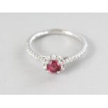 AN 18CT WHITE GOLD, ROUND SPINEL (0.50cts) AND DIAMOND (0.29cts) HALO RING.