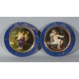 A PAIR OF CLASSICAL PLATES with blue borders. 10ins diameter.