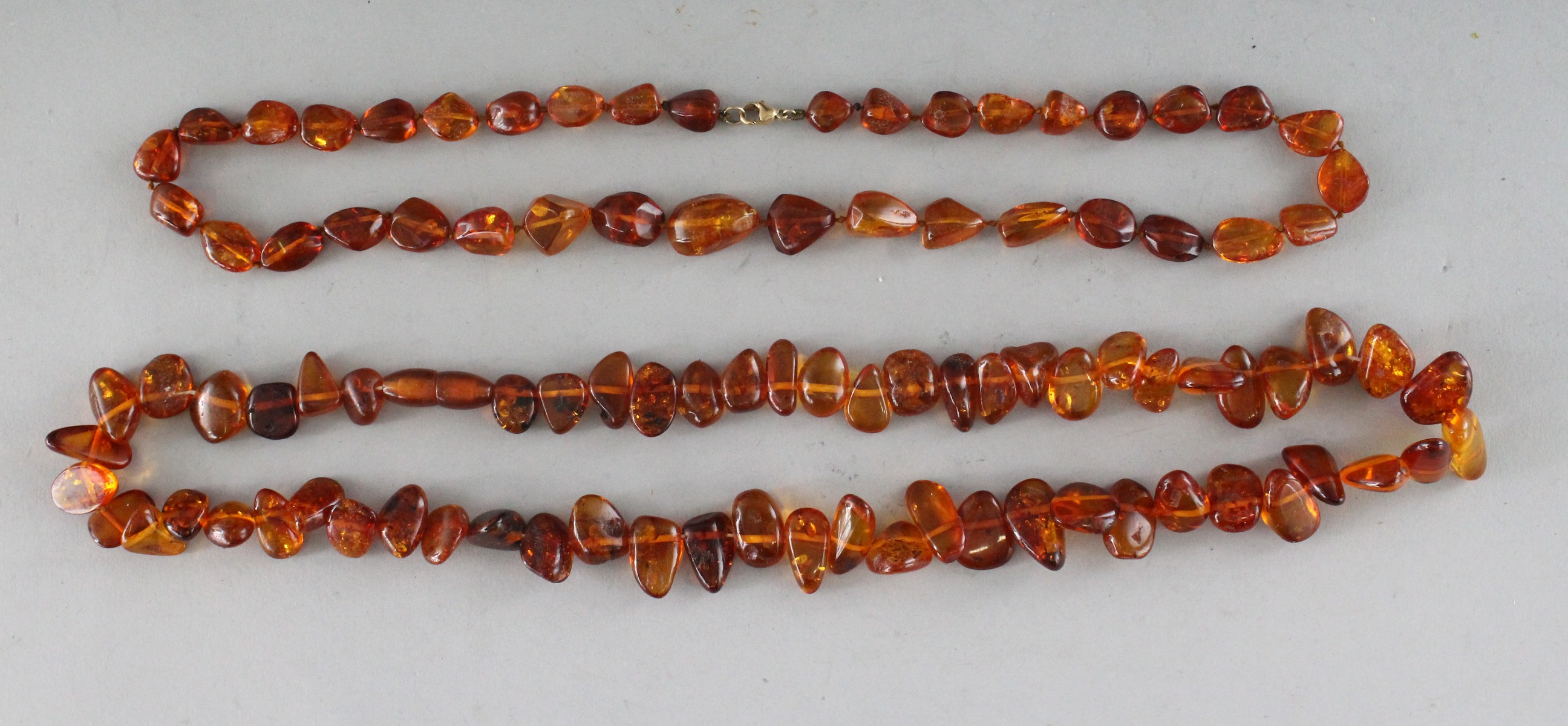 TWO AMBER NECKLACES.