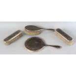 A SILVER AND TORTOISESHELL HAND MIRROR AND THREE BRUSHES. Birmingham 1919. Maker: LS for LEVI &