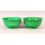 A PAIR OF CHINESE GREEN GROUND MOULDED DRAGON BOWLS, 16cm diameter.