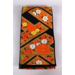 A FINE QUALITY JAPANESE EMBROIDERED SILK FUKURO OBI TIE, with a black ground and floral and gilt