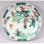 A CHINESE FAMILLE VERTE CIRCULAR PORCELAIN DISH, painted with figures in a garden setting, Kangxi