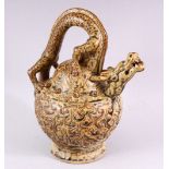 AN UNUSUAL TREACLE GLAZED POTTERY WINE EWER, with dragon handle and spout, 23cm high.