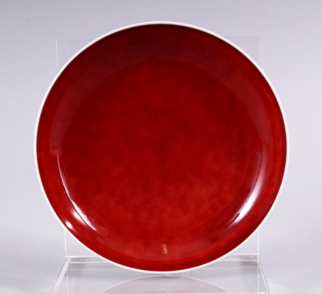 A CHINESE COPPER RED GLAZED PORCELAIN DISH, the base with incised double rings around a six