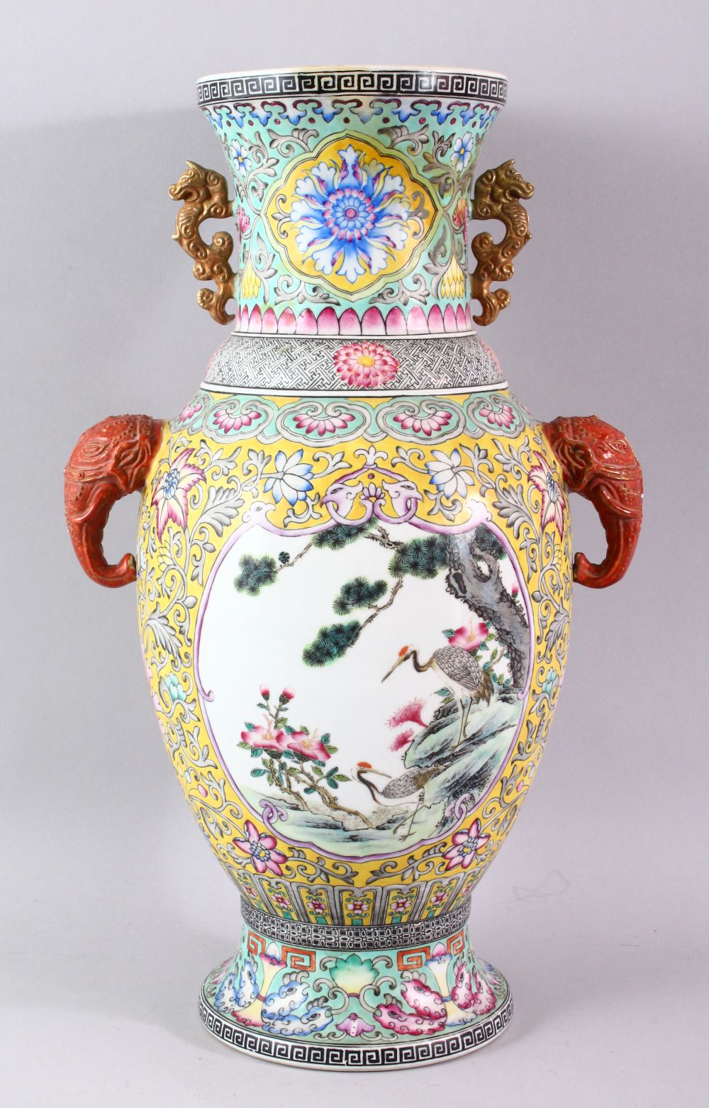 A GOOD LARGE FAMILLE ROSE BALUSTER SHAPE VASE, with coral coloured elephant head handles, painted