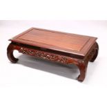 AN EARLY 20TH CENTURY CHINESE CARVED HARDWOOD COFFEE TABLE, with a carved frieze and curving legs,