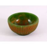 A GREEN JADITE CIRCULAR BOWL with beaded decoration all over, 11.5cm diameter.