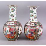 A PAIR OF 20TH CENTURY FAMILLE ROSE BALUSTER VASES, painted with figures in an interior, 30cm high.