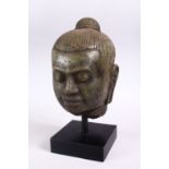 A CAMBODIAN CARVED STONE BUST OF A MAN, mounted on a plinth base, overall height 28cm.